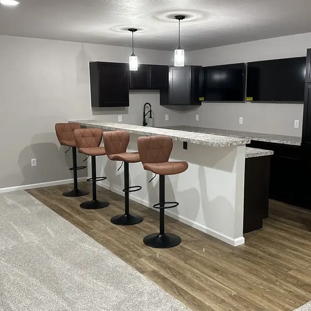 Beautiful basement kitchen / bar complete with cabinetry, dual height countertops and lighting