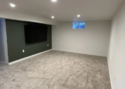 Finished basement with new carpet, lighting, accent wall and big screen TV.
