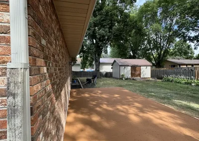 A rust-colored concrete patio going the full length of the house.