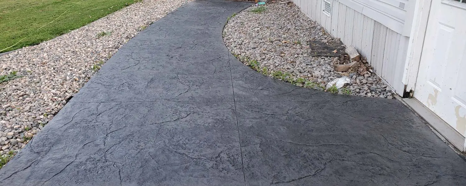 Stamped and dyed concrete path along side a home.
