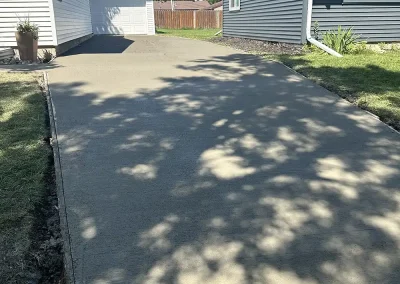 A long concrete driveway going from the street all the way to the garage.