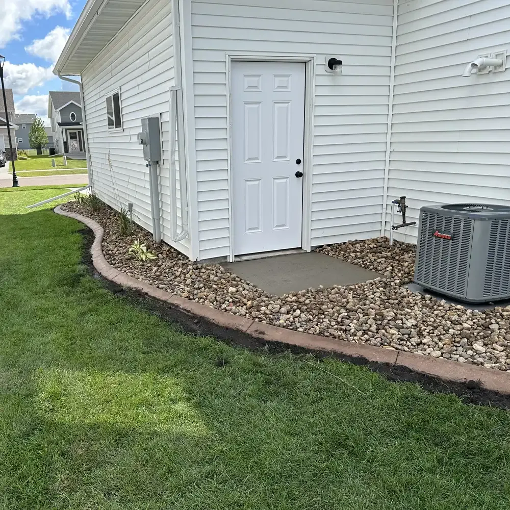 Nicely landscaped side yard with block and rock edging and green grass